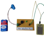 Circuit diagram of a DIY rain alarm project using a rain sensor, NPN transistor, and buzzer to detect water droplets.